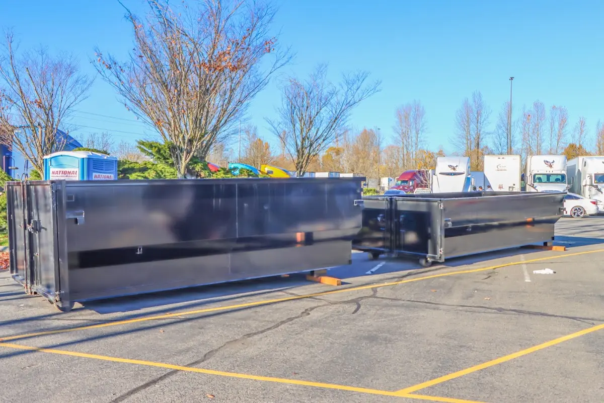 Professional dumpster rental service with roll-off container on residential driveway in Orchard Homes